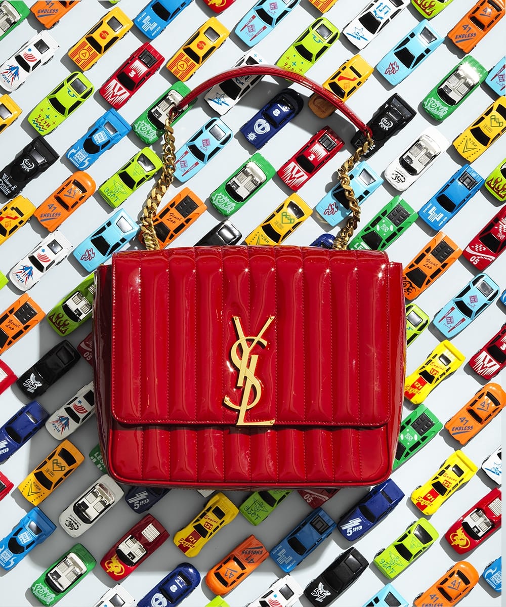 designer bag in front of a background which was made out of matchbox cars